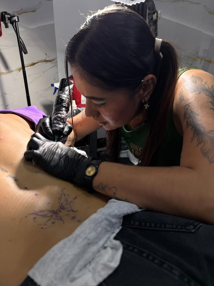 Alumna tatuando cliente
